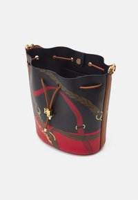 Bucketväska gjord av belagd duk med en mörkblå botten och röda samt gyllene detaljer, lädersnodd och logotypdetalj i guld.