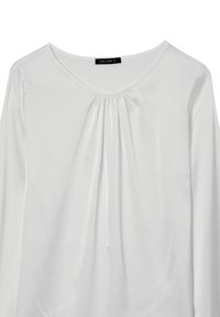 Blusa bianca a maniche lunghe realizzata in tessuto leggero e morbido. Presenta un collo rotondo e pieghe sottili nella parte anteriore. Etichetta del marchio visibile.
