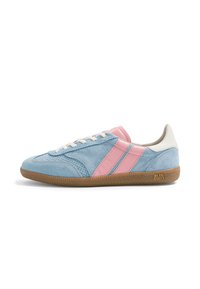Baskets en daim bleu clair avec des bandes en cuir rose, lacets blancs, talon beige et semelle texturée marron, vue de côté sur fond blanc.