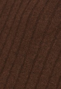 Brun tyg med en mjuk textur som har subtila vertikala ränder. Ytan verkar ludnare, vilket skapar ett rikt, strukturerat utseende.