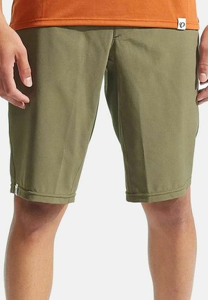 Olivgrüne Shorts aus strukturiertem Stoff, mit einem gesäumten Saum, seitlichen Taschen und einem kleinen Markenetikett in der Nähe des Bundes.