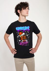Camiseta de algodón negra con un diseño gráfico colorido de un personaje de dibujos animados con un boombox, el texto "GANGSTER WRAPPER" y acentos juguetones.