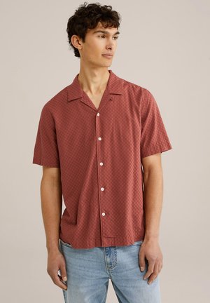 Camicia a maniche corte in un tessuto testurizzato marrone-rosato con motivo a diamante. Presenta un colletto classico e bottoni bianchi.
