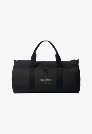 Czarny cylindryczny torba podróżna z podwójnymi uchwytami, zamkiem błyskawicznym oraz logo Calvin Klein na przedniej kieszeni.