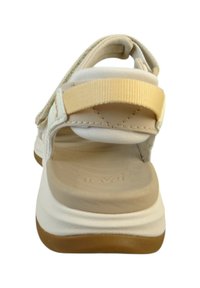 Hvide og tan sandaler med en polstret fodseng, holdbare remme og justerbare lukninger. Har en gummisål for godt greb.