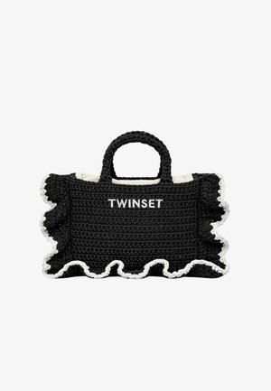 Čierna háčkovaná kabelka s bielym volánovým okrajom, dvoma krátkymi rúčkami a výšivkou "TWINSET" v bielej farbe na prednej strane.