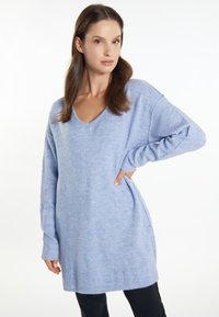 Pulover supradimensionat, de culoare albastru deschis, cu decolteu în V, mâneci lungi și tiv elastic. Fabricat dintr-un material moale și pufos, cu o ușoară textură.