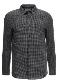 Camisa de manga larga con botones en patrón a cuadros en negro y gris, con cuello, bolsillo frontal y textura de tela suave.