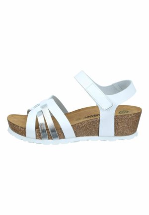 White and silver strappy wedge sandal with cork sole and adjustable ankle strap.