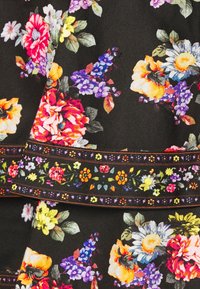 Blommig tyg med mörk bakgrund som har livfulla rosor, prästkragar och violer, med en dekorativ kant av små blommor och blad.