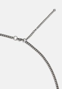 Collana in metallo con catena composta da anelli interconnessi in tonalità argento, chiusura rotonda e design a lunghezza regolabile con una singola catena di estensione.