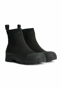 Botas de tobillo negras impermeables con un acabado de goma suave, fuelles elásticos y suela texturizada. Incluyen tiradores para facilitar su uso.