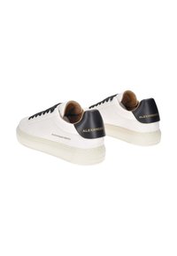 Sneakers bianchi in pelle con accenti neri, dotati di lacci neri, colletto imbottito e branding in rilievo sul tallone. Suola in gomma testurizzata.