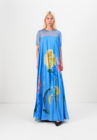 Long blue floral dress featuring short sleeves, sheer bodice, and large multi-colored flower prints in yellow, pink, and green.