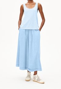 Světle modrý pruhovaný top s kulatým výstřihem ve střihu tank top, doplněný o jednobarevnou světle modrou maxi sukni s nařaseným pasem a postranními kapsami.