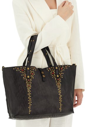Borsa tote in pelle nera con borchie decorative dorate e rosse, dotata di manici doppi e forma strutturata.