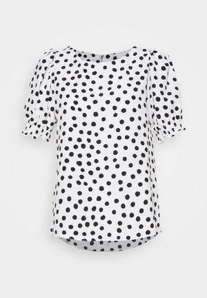 Weiße Bluse mit schwarzen, unregelmäßigen Punkten, rundem Ausschnitt und kurzen, gepufften Ärmeln mit elastischen Bündchen.