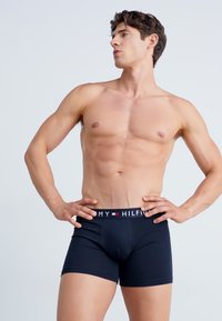 Boxer-briefs en coton noir avec une taille élastique de marque dotée d'accents rouge et blanc, design ajusté et texture lisse.