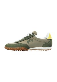 Baskets pour hommes en vert olive, avec une tige en mesh et suède, des lacets blancs, un tirant jaune au talon et une semelle en caoutchouc beige avec un relief texturé.