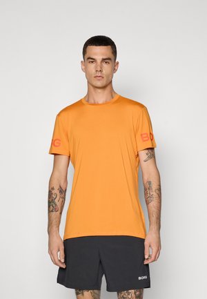 T-shirt orange à manches courtes avec col rond, présentant 'BORG' en rouge sur la manche gauche. Le tissu semble lisse et léger.