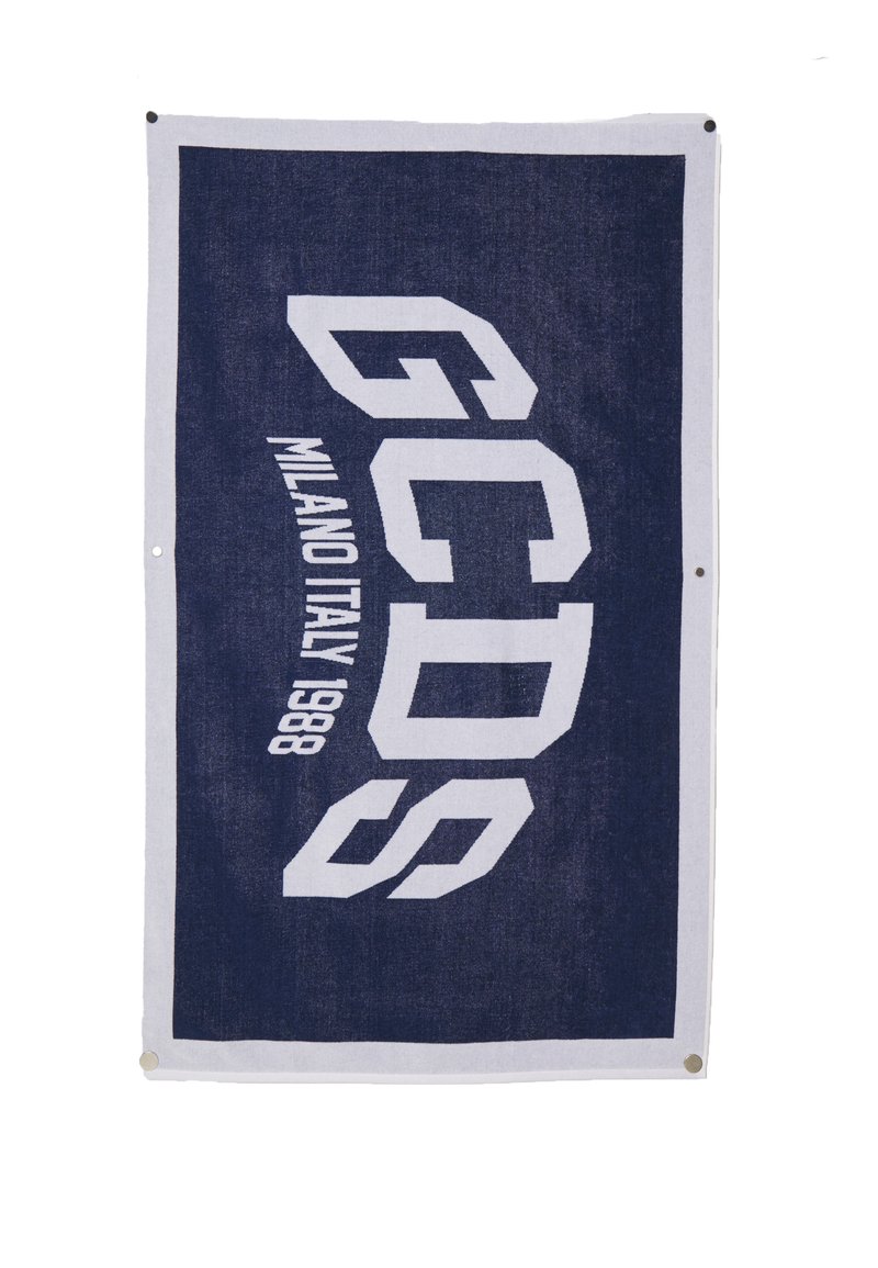 Tissu bleu marine avec le texte en blanc et en gras "GCDS MILANO ITALY 1988", avec des œillets métalliques dans les coins pour l'accrochage.