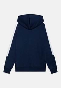 Sudadera azul marino con capucha forrada, acentos laterales blancos y puños de canalé. Fabricada con un tejido suave y de ajuste relajado, diseñada para la comodidad.