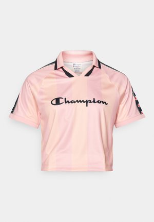Helles rosa, kurz geschnittenes Jersey mit vertikalen Streifen, versehen mit einem schwarzen Kragen und schwarzen Akzenten. "Champion"-Logo in fetter schwarzer Schrift auf der Vorderseite.