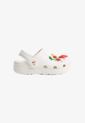 Sabot en style croc blanc, fabriqué à partir d'un matériau flexible, ornée de décorations de fruits multicolores et dotée de trous de ventilation sur les côtés.