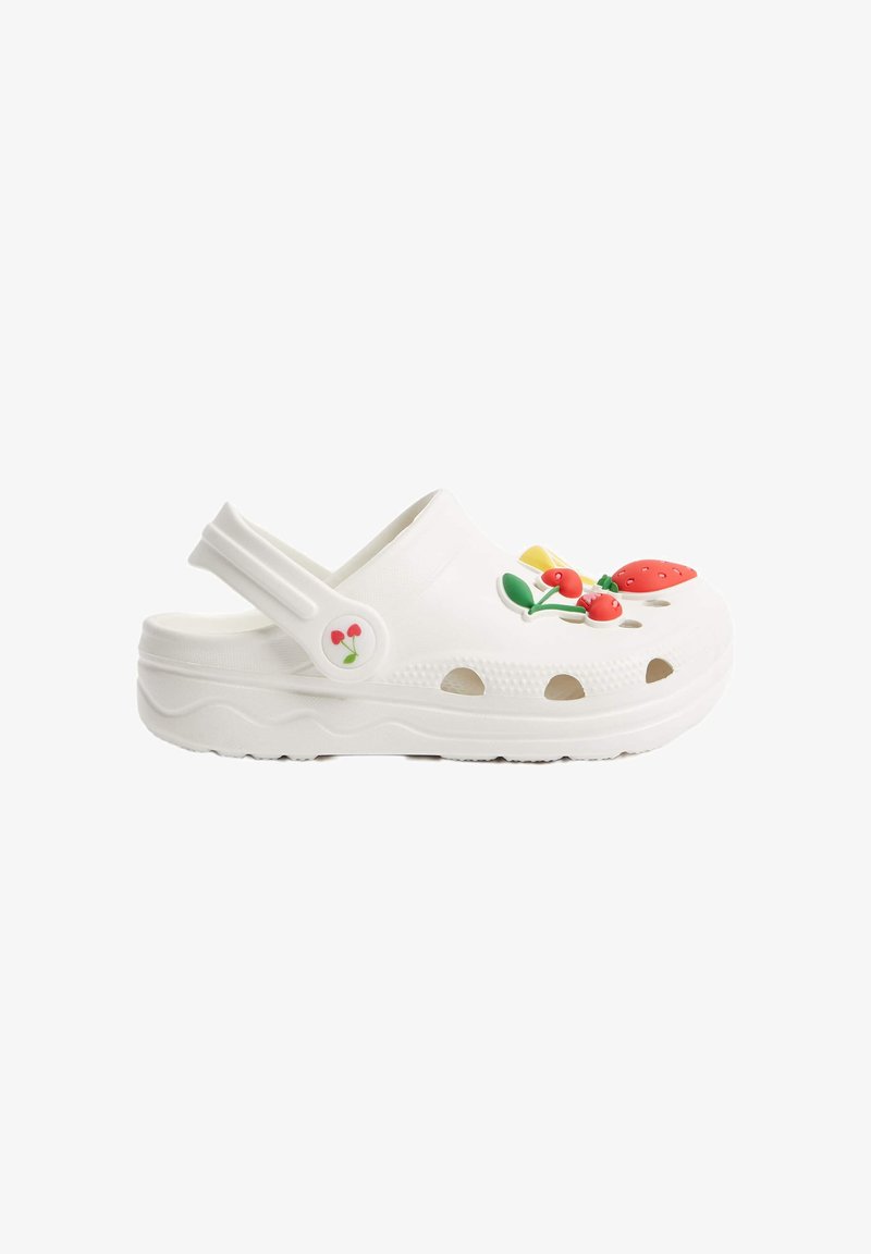 Vita croc-stil klädd sandal tillverkad av flexibelt material, med flerfärgade fruktsmycken och ventilationshål längs sidorna.