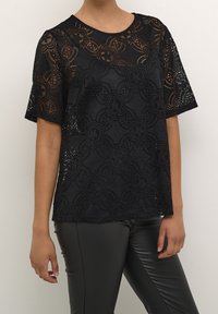 Czarny koronkowy t-shirt w kwiatowy wzór, z krótkimi rękawami i okrągłym dekoltem, zestawiony z czarnymi, dopasowanymi spodniami.