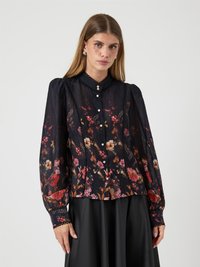 Blomstrete bluse i mørk marineblå stoff, med fargerike blomstmønstre, puffermer, krage og knappelukking foran med perleforsterkninger.
