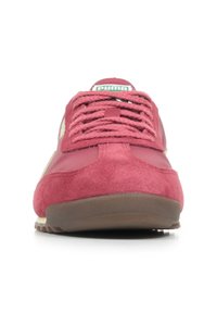 Sneaker in suede rosso e materiale sintetico con punta arrotondata, lacci piatti, suola in gomma e logo verde sulla linguetta. Accentuato con dettagli beige chiaro.