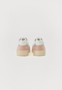 Baskets blanches et roses avec une texture en daim, présentant un col de cheville rembourré et une semelle en caoutchouc beige épaisse.