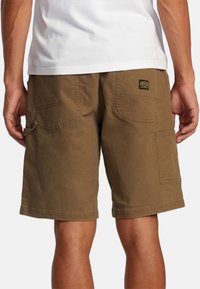 Brune cargo shorts lavet af bomuld, med to baglommer og en sidelomme, samt et mærke på den højre baglomme. Klassisk pasform.
