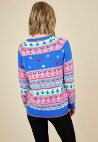 Blauer und rosa gestrickter Pullover mit festlichen Mustern von Sternen, Weihnachtsbäumen, Rentieren und Santa-Gesichtern sowie gerippten Bündchen und Saum.