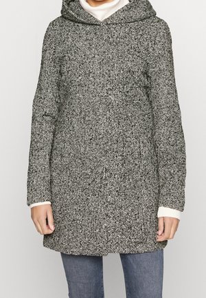 Cappotto a motivo nero e bianco con cappuccio, maniche lunghe e tessuto testurizzato; presenta polsini lavorati a maglia e una vestibilità dritta.