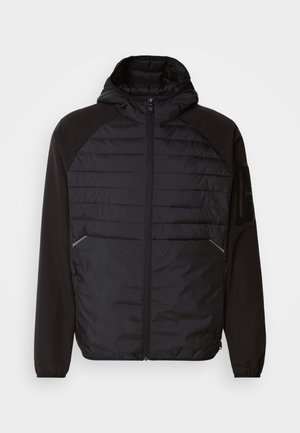 Veste noire avec capuche, présentant un design matelassé à l'avant, des manches lisses et des poches zippées. Tissu texturé avec une silhouette ajustée.
