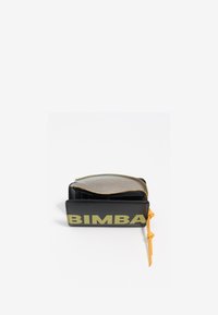 Cartera negra hecha de material sintético con un acabado brillante. Presenta "BIMBA" en letras grandes amarillas, cierre con cremallera y un acento amarillo.