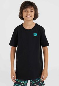 Camiseta de algodón negra con mangas cortas y cuello redondo, que presenta un pequeño logo multicolor en el lado izquierdo del pecho.