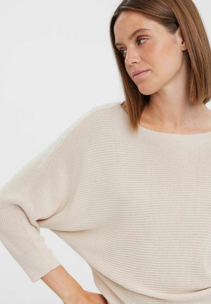 Light beige, loose-fitting knit sweater with wide boat neckline and three-quarter sleeves, featuring textured ribbed pattern throughout.