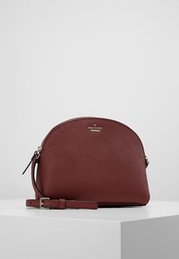 Burgunderfarbene Lederhandtasche mit abgerundetem oberen Teil, goldener Hardware und einem abnehmbaren Riemen. Verfügt über eine strukturierte Oberfläche und ein Logodetail auf der Vorderseite.