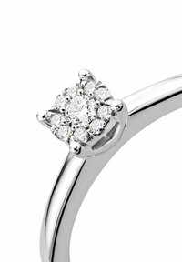 Anello a cluster di diamanti con una pietra centrale tonda circondata da diamanti più piccoli, montato su una fascia in argento lucido con una finitura liscia.