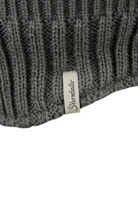 Graue Strickmütze mit strukturiertem Rippenmuster, versehen mit einem kleinen Stoffetikett, das "Sterntaler" beschriftet ist. Der Stoff wirkt warm und dick.