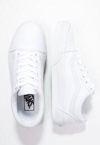 Sneakers bianchi in tela con design a basso profilo, dotati di una suola in gomma testurizzata, chiusura con lacci sul davanti e un distintivo dettaglio a striscia laterale.