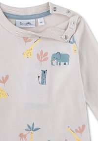 Hellbeige Langarmhemd mit Tiermotiven. Verfügt über einen blauen Kragen, einen Druckknopfverschluss und Illustrationen von Elefanten, Giraffen und Pflanzen.