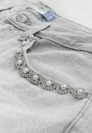 Gray denim jeans featuring a decorative trim with clear and white pearl-like embellishments, enhancing the pockets with a textured appearance.