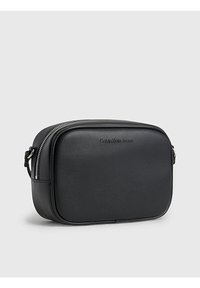 Borsa a tracolla in ecopelle nera con forma rettangolare, chiusura con zip e logo in rilievo. Presenta una superficie texturizzata e una tracolla regolabile.