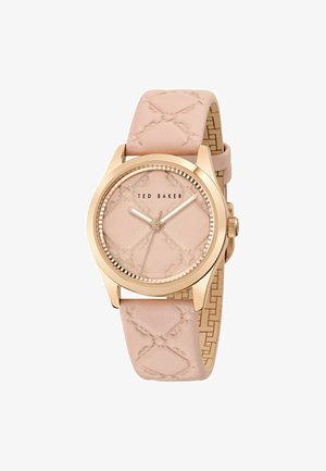 Rosa Lederarmbanduhr mit strukturiertem Rundzifferblatt, goldfarbenen Akzenten und einem gemusterten Zifferblatt. Mit prominentem Markennamen "Ted Baker".