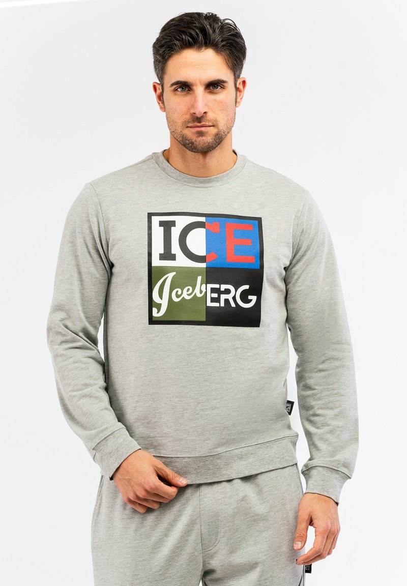 Grauer Pullover mit einem mehrfarbigen Grafikdesign und dem Schriftzug "ICE" und "Iceberg" in Rot, Blau, Grün und Weiß. Klassischer Rundhalsausschnitt und Bündchen.