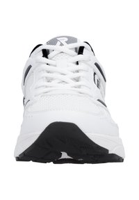 Chaussure de sport blanche avec tige en mesh, accents noirs, et semelle extérieure en caoutchouc texturée. Dispose d'une fermeture à lacets avec œillets renforcés.